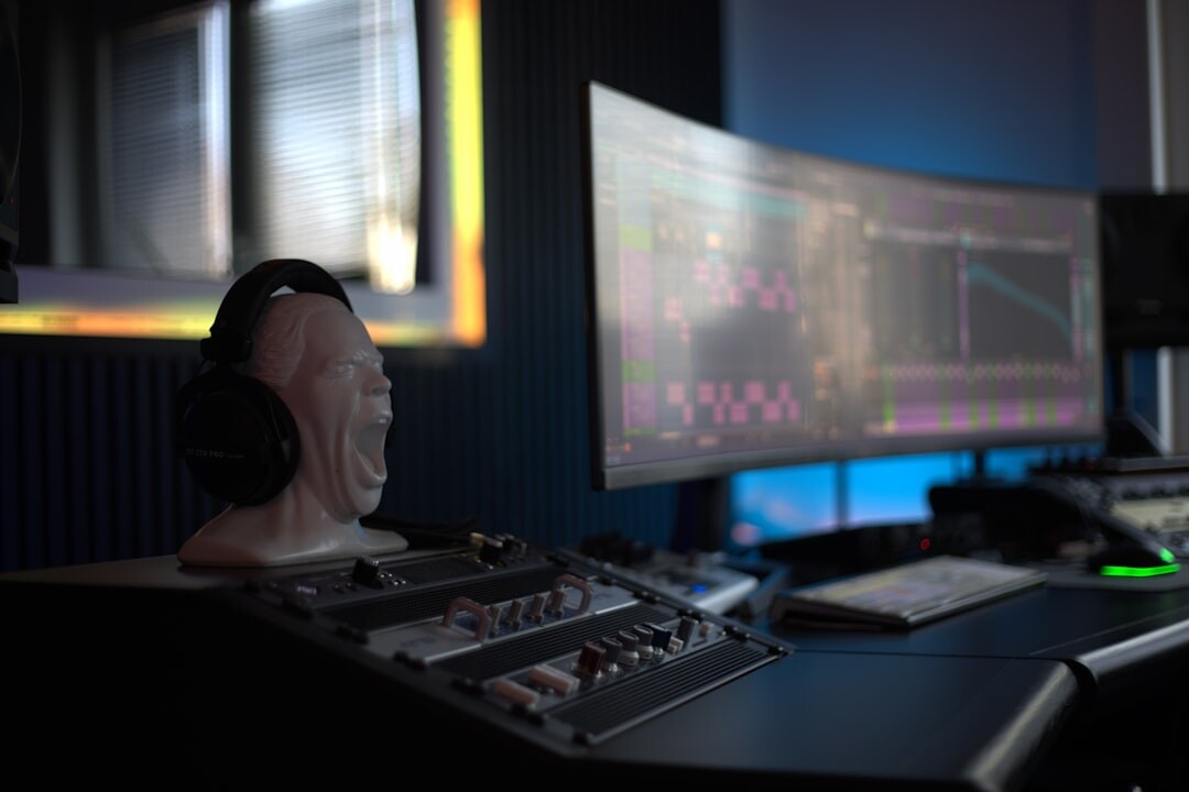 Technical director at a broadcast mixing desk with multiple monitors