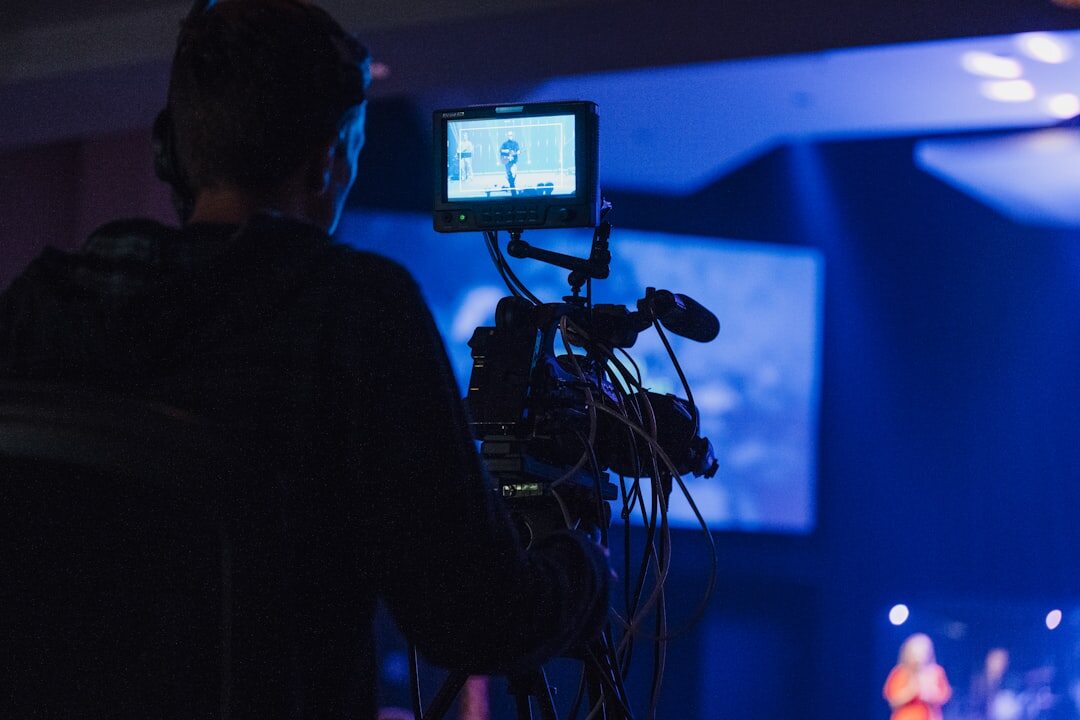 Journalist interviewing a remote guest displayed on a large studio screen